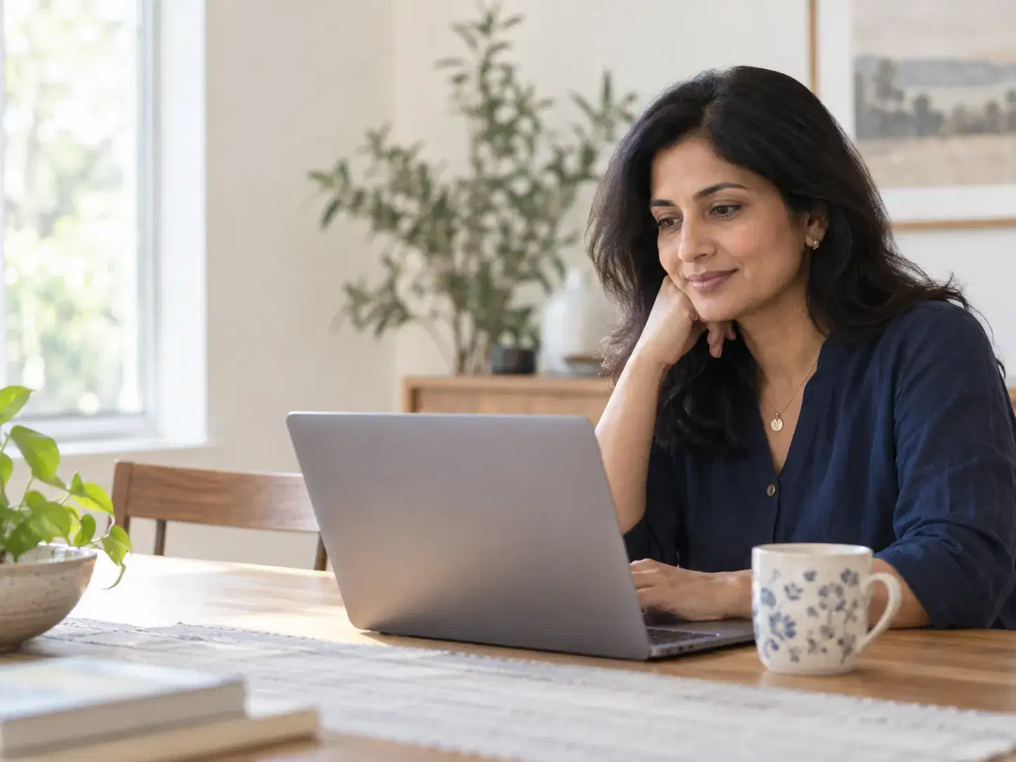 A woman reviewing information on her laptop at home