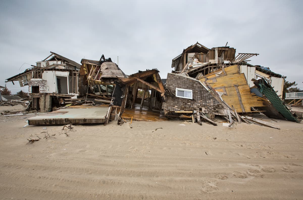 Damaged home with fallen tree and debris after a severe storm
